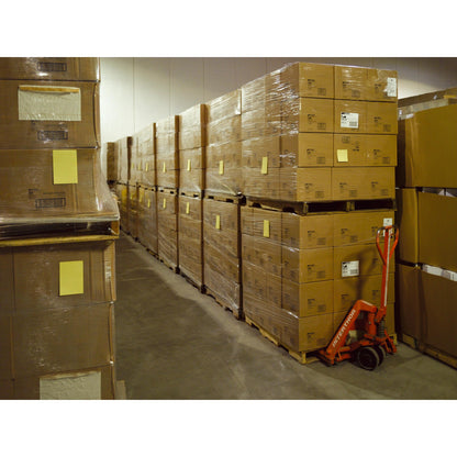 In einem Lagerhaus sind Stapel von Post-it® Super Sticky Notes im Großformat, Ultra Gelb (101 x 152 mm, 90 Blatt/Block, 6 Blöcke), von 3M Deutschland GmbH, auf Paletten verpackt. Ein roter Handhubwagen steht daneben.