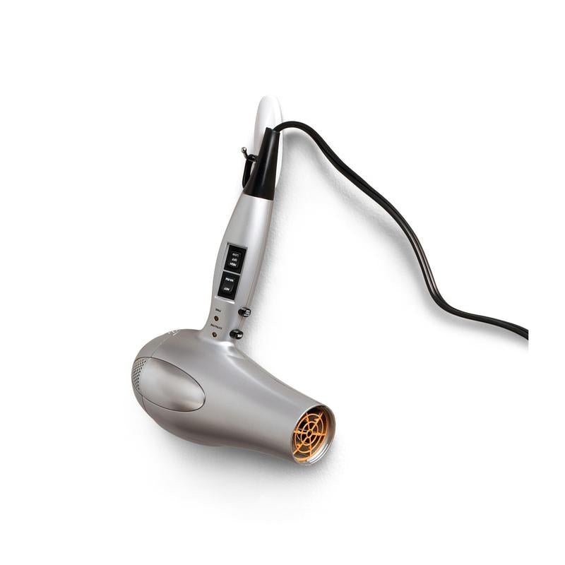 Un sèche-cheveux argenté-blanc avec une grille de ventilation orange pend sans dommage à son câble noir sur un crochet métallique moyen Command™, 17068, de 3M Deutschland GmbH avec technologie adhésive, sur un mur blanc. La poignée dispose de boutons et de commutateurs pour les réglages.